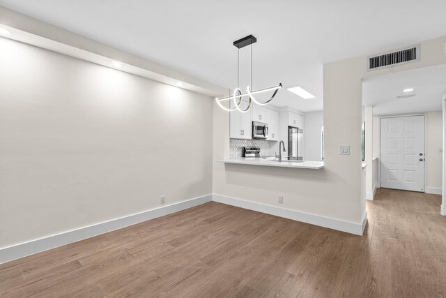 7350 Kinghurst Dr Unit 305, Delray Beach, FL 33446 - unfurnished dining area featuring baseboards, wood finished floors, visible vents, and recessed lighting