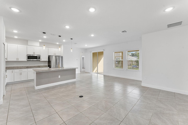2132 SW Vista Rd, Port Saint Lucie, FL 34953 - kitchen with appliances with stainless steel finishes, visible vents, open floor plan, light tile patterned flooring, and a center island with sink