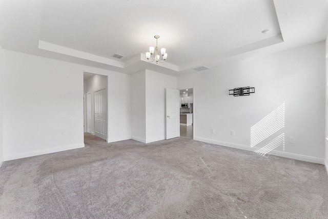 2132 SW Vista Rd, Port Saint Lucie, FL 34953 - carpeted spare room with visible vents, a raised ceiling, a chandelier, and baseboards