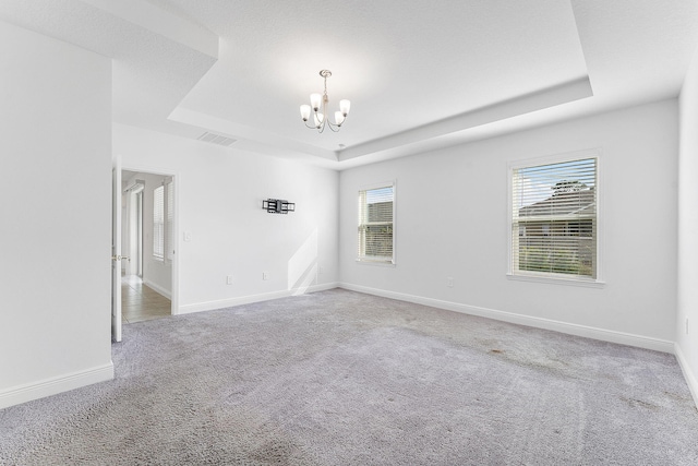 2132 SW Vista Rd, Port Saint Lucie, FL 34953 - unfurnished room with a notable chandelier, baseboards, carpet floors, and a tray ceiling