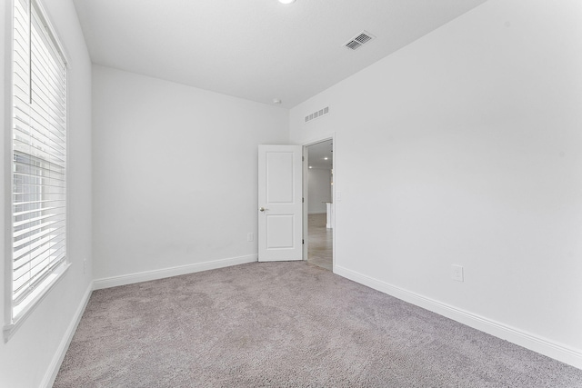 2132 SW Vista Rd, Port Saint Lucie, FL 34953 - empty room with carpet flooring, baseboards, lofted ceiling, and visible vents