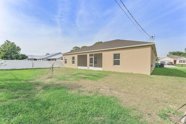 2132 SW Vista Rd, Port Saint Lucie, FL 34953 - rear view of house featuring fence, stucco siding, and a yard
