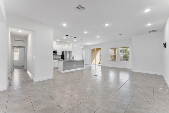 2132 SW Vista Rd, Port Saint Lucie, FL 34953 - unfurnished living room featuring light tile patterned floors, recessed lighting, and visible vents