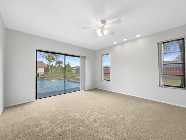 spare room with baseboards, ceiling fan, and carpet floors