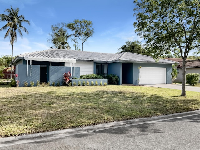 ranch-style home with a front lawn, stucco siding, driveway, a tiled roof, and an attached garage