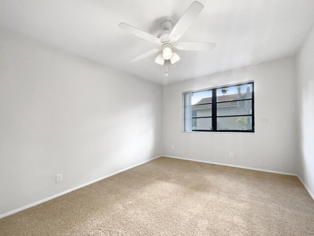 spare room with ceiling fan, carpet flooring, and baseboards
