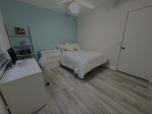 bedroom with baseboards, light wood-type flooring, and ceiling fan