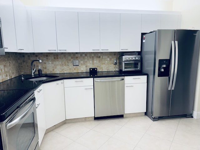 kitchen with white cabinetry, stainless steel appliances, backsplash, and a sink