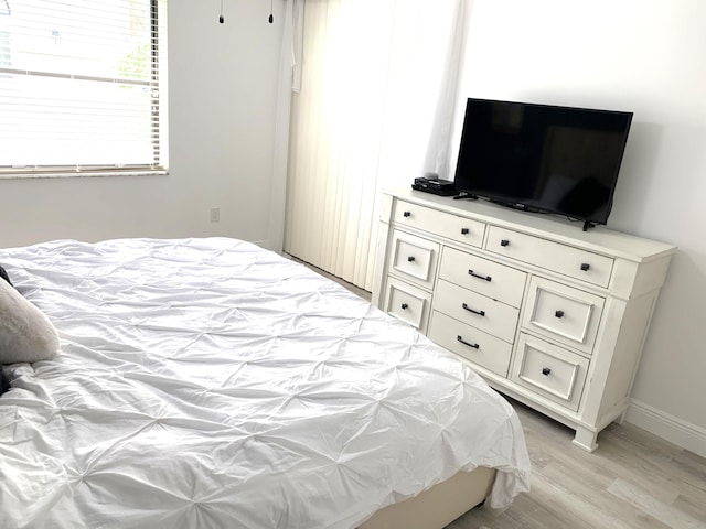 bedroom with baseboards and light wood-type flooring