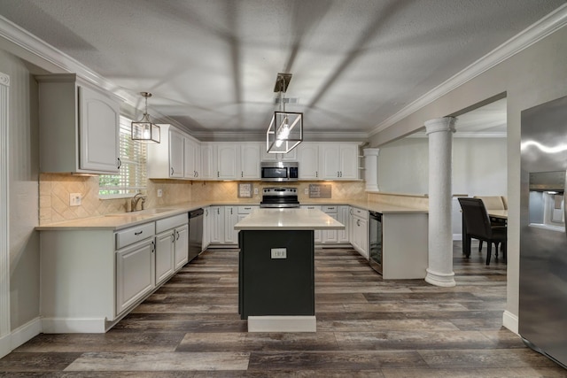 kitchen with a sink, stainless steel appliances, a kitchen island, decorative columns, and wine cooler