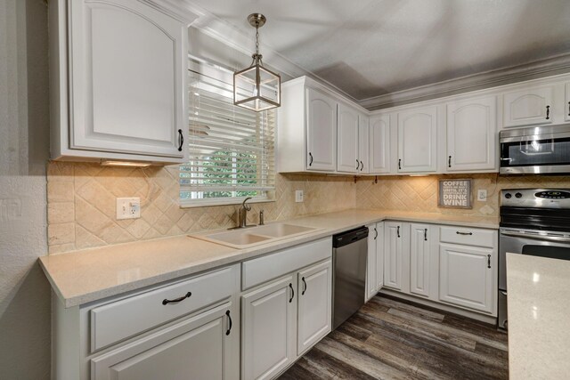 kitchen featuring white cabinetry, a sink, appliances with stainless steel finishes, dark wood finished floors, and hanging light fixtures