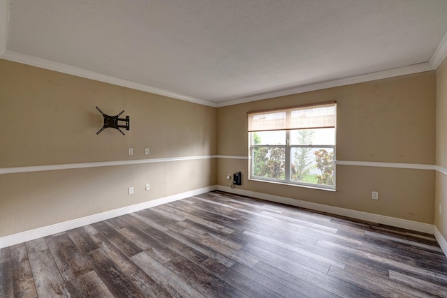 spare room with crown molding, baseboards, and dark wood finished floors