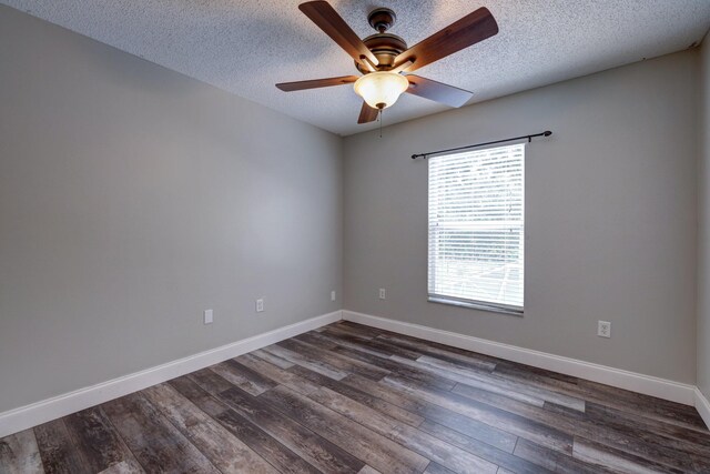 empty room featuring a textured ceiling, ceiling fan, dark wood-style floors, and baseboards