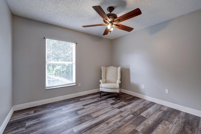 unfurnished room with baseboards, wood finished floors, ceiling fan, and a textured ceiling