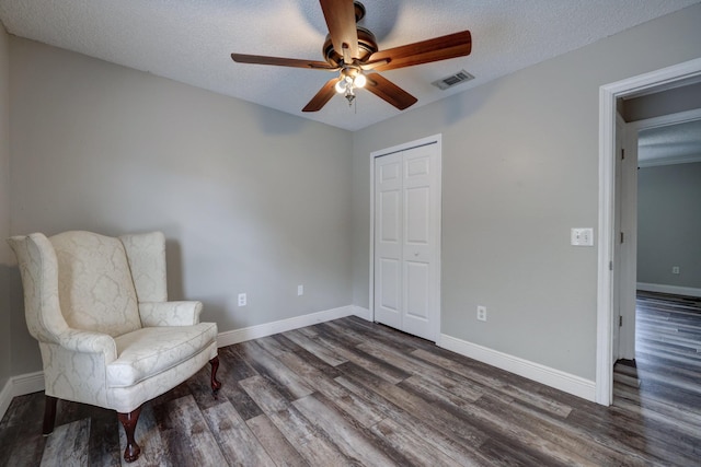 unfurnished room featuring a textured ceiling, visible vents, baseboards, dark wood-style flooring, and a ceiling fan