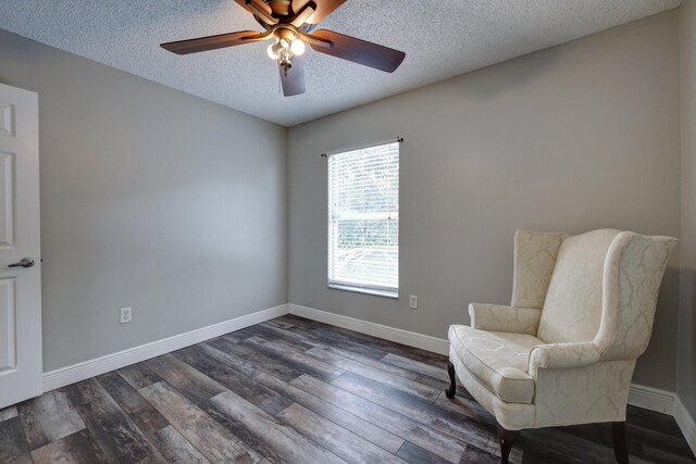 living area featuring a textured ceiling, dark wood-style flooring, ceiling fan, and baseboards