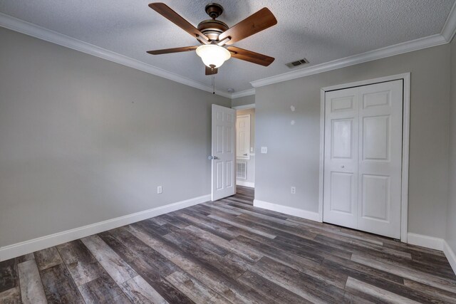 unfurnished bedroom with dark wood-style flooring, crown molding, visible vents, baseboards, and a textured ceiling