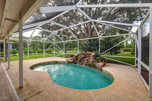 pool with glass enclosure, a yard, and a patio area