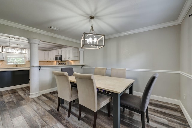 dining area with a chandelier, crown molding, and dark wood finished floors