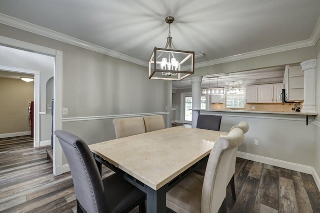 dining space featuring crown molding, dark wood-style floors, and an inviting chandelier