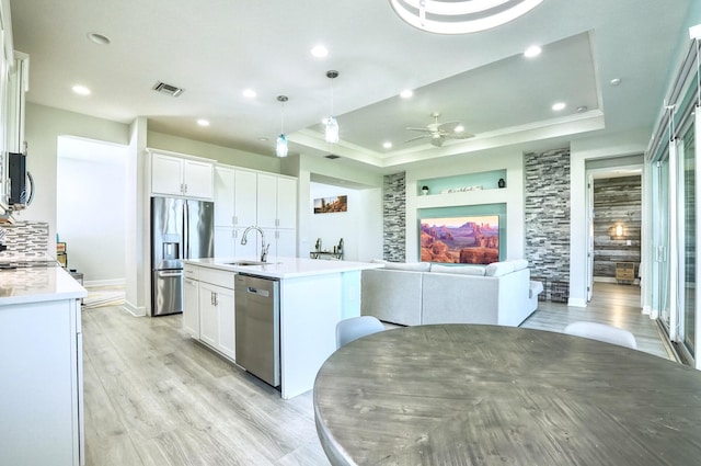 15581 Goldfinch Cir, The Acreage, FL 33470 - kitchen featuring stainless steel appliances, a sink, a raised ceiling, light wood-style floors, and a ceiling fan
