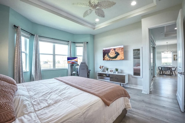 15581 Goldfinch Cir, The Acreage, FL 33470 - bedroom with multiple windows, wood finished floors, a tray ceiling, recessed lighting, and baseboards
