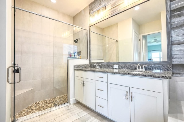 15581 Goldfinch Cir, The Acreage, FL 33470 - bathroom featuring a stall shower, double vanity, wood finished floors, and recessed lighting