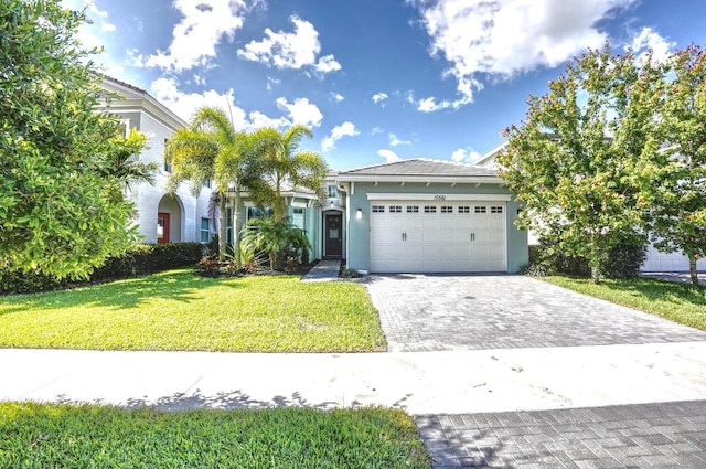 15581 Goldfinch Cir, The Acreage, FL 33470 - view of front of house featuring stucco siding, a garage, a front lawn, and decorative driveway