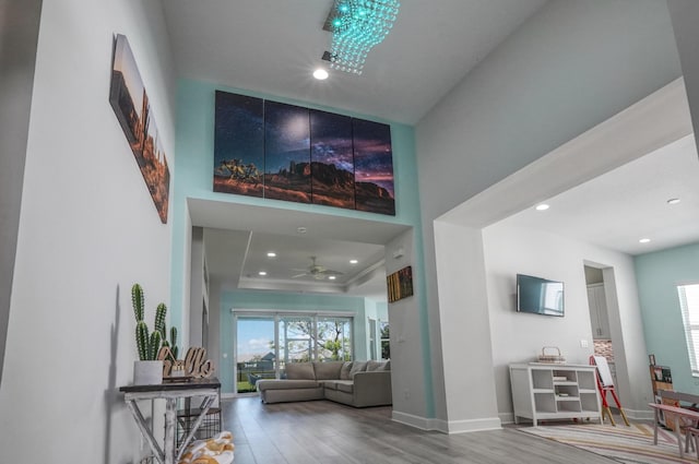 15581 Goldfinch Cir, The Acreage, FL 33470 - living room featuring plenty of natural light, wood finished floors, ceiling fan, recessed lighting, and a towering ceiling