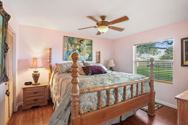 bedroom with ceiling fan, wood finished floors, and baseboards