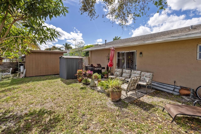 view of yard featuring fence, a patio area, a shed, and an outbuilding