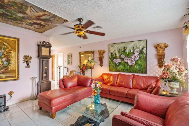tiled living area with a ceiling fan, visible vents, a textured ceiling, and baseboards