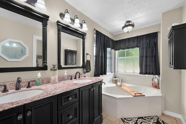 full bathroom with a textured ceiling, a garden tub, tile patterned floors, and a sink