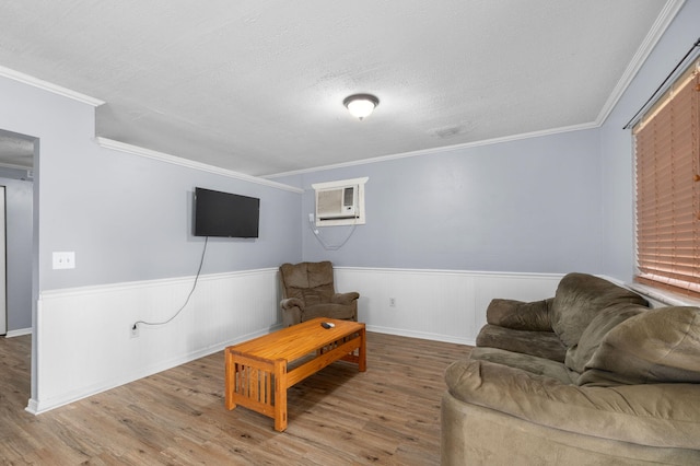 living room with wainscoting, wood finished floors, and a wall unit AC