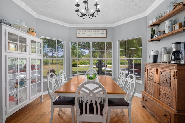 dining area featuring a notable chandelier, a textured ceiling, and light wood-style floors