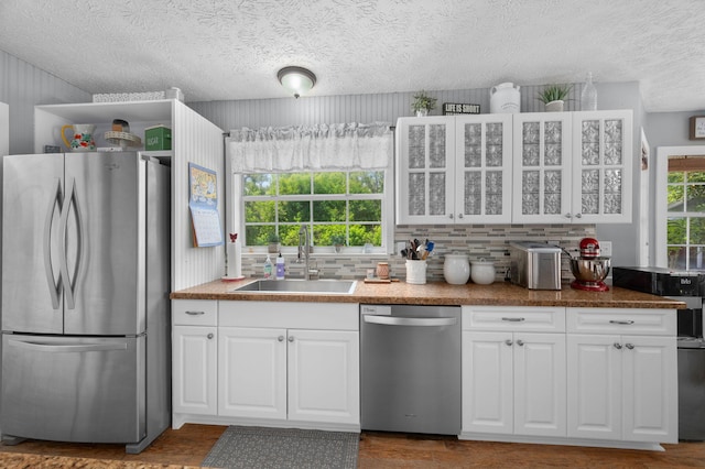 kitchen with a sink, white cabinetry, appliances with stainless steel finishes, and tasteful backsplash