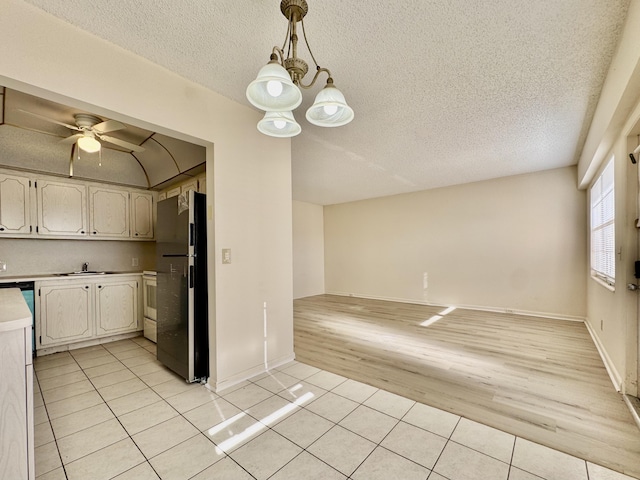 82 Dorset Unit B, Boca Raton, FL 33434 - kitchen with freestanding refrigerator, light tile patterned floors, light countertops, a textured ceiling, and open floor plan