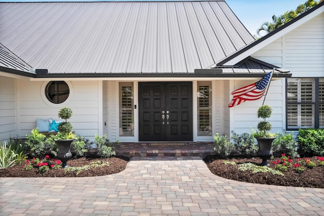 property entrance with covered porch and metal roof
