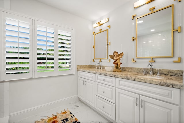 bathroom with double vanity, a sink, marble finish floor, and baseboards