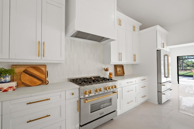 kitchen with white cabinetry, premium appliances, wall chimney range hood, and light countertops