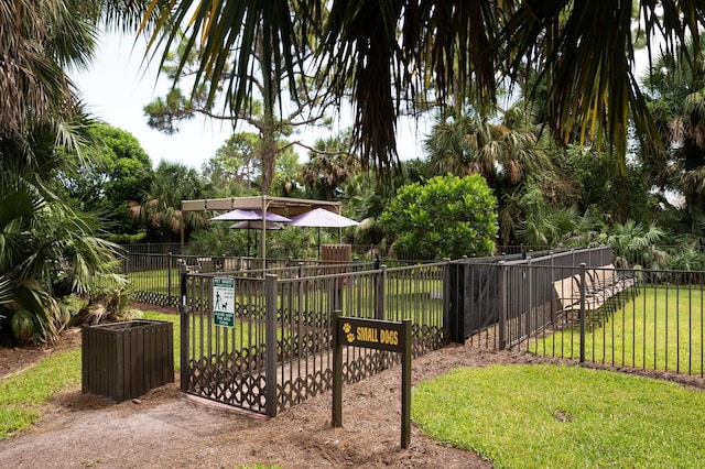 view of community featuring a lawn and fence