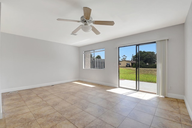 spare room featuring light tile patterned floors, visible vents, ceiling fan, and baseboards