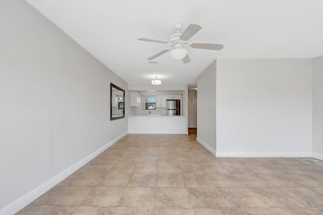 unfurnished room featuring a ceiling fan and baseboards