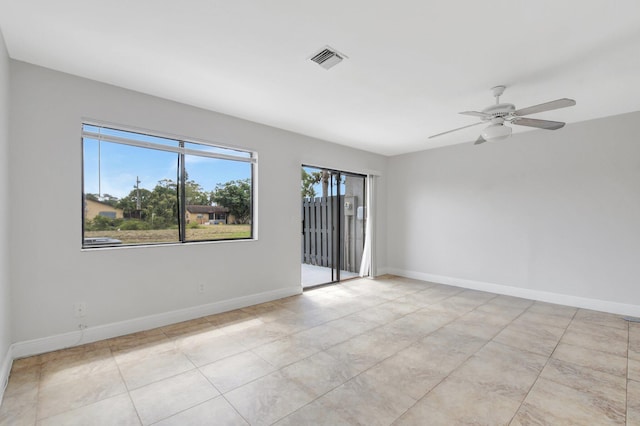 unfurnished room featuring baseboards, visible vents, a ceiling fan, and light tile patterned flooring