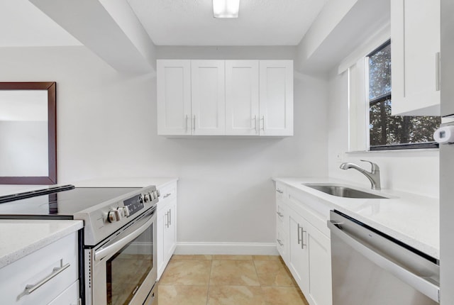 clothes washing area with light tile patterned floors, baseboards, and a sink
