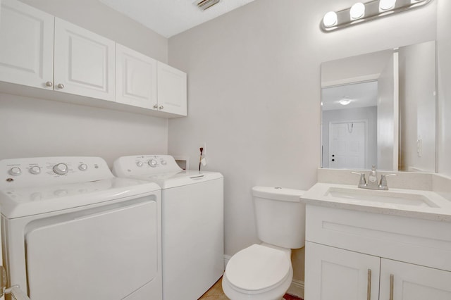 bathroom with toilet, washer and dryer, visible vents, and vanity