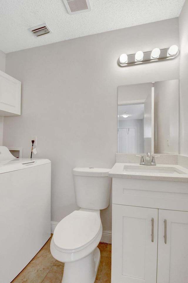 bathroom with visible vents, toilet, washer / clothes dryer, and vanity