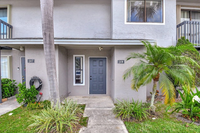 doorway to property featuring stucco siding