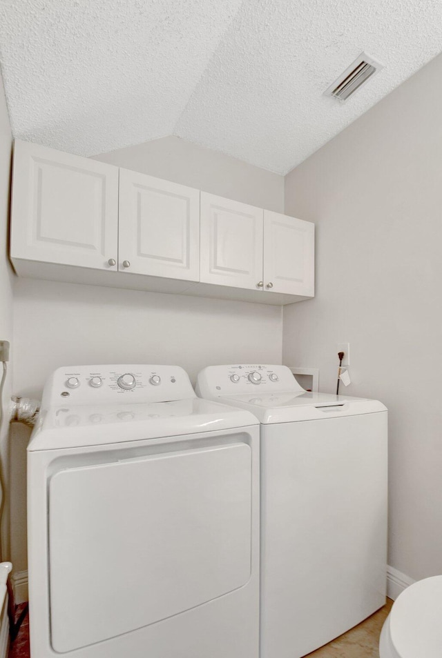 laundry area featuring baseboards, visible vents, a textured ceiling, and independent washer and dryer