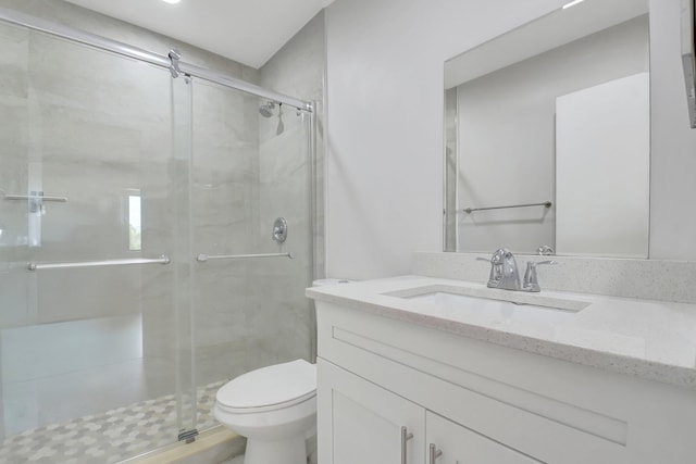 full bath with a stall shower, toilet, and vanity